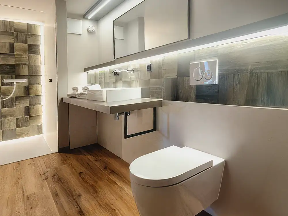 Referenz Sanitär, Goldener Anker in Wachau mit edler Amatur, barrierefreier Toilette und beleuchteter Waschzelle